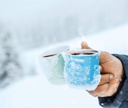 Cups of hot coffee on the snow. Christmas landscape.の写真素材