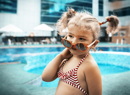 Little beautiful girl resting in the pool and learning to swimの写真素材