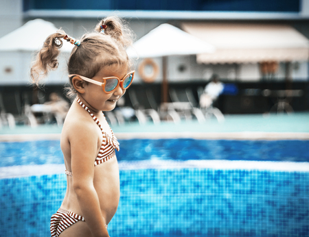 Little beautiful girl resting in the pool and learning to swimの写真素材