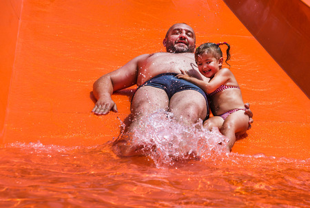Dad teaches a little daughter to swim in the pool. Aquapark.の写真素材