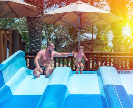 Dad teaches a little daughter to swim in the pool. Aquapark.