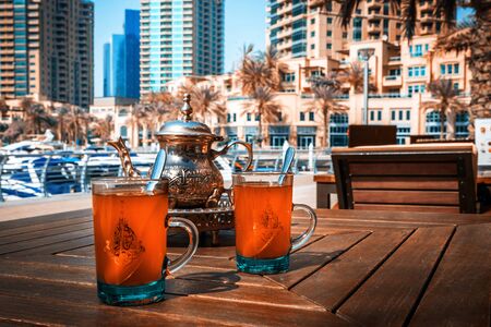 Tea in traditional oriental cups. Panoramic view of Dubai, UAE.の写真素材