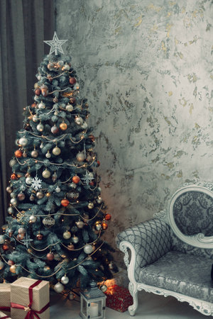 Xmas decorated fir tree in studio with chairの写真素材
