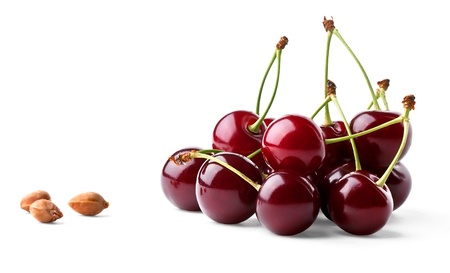 Juicy ripe cherries and cherrystones isolated on white backgroundの写真素材