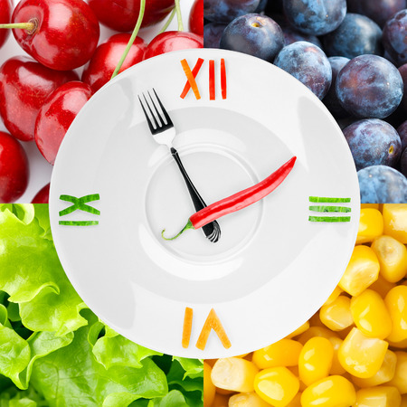 Food clock with vegetables and fruits as background. Healthy food conceptの写真素材