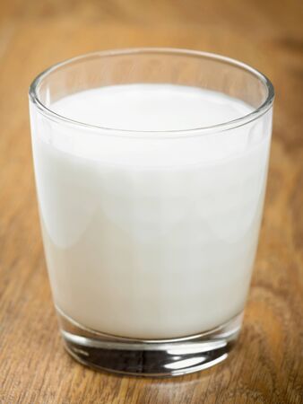 Glass of milk on wooden backgroundの写真素材