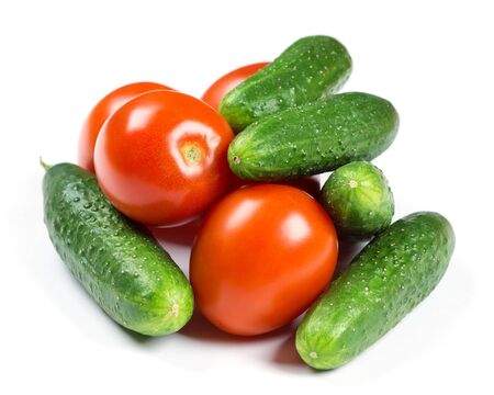 Fresh tomatoes and cucumbers on white backgroundの写真素材