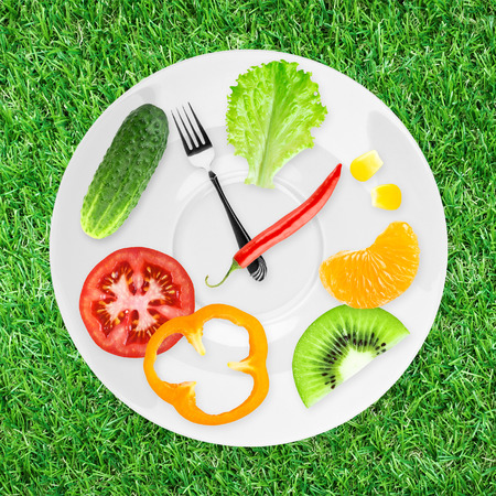 Food clock with fruits and vegetables. Healthy food conceptの写真素材