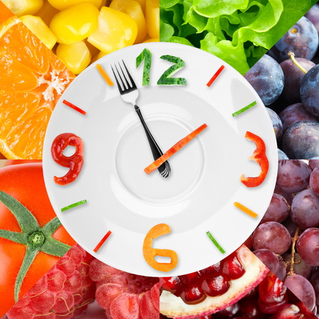 Food clock with vegetables and fruits as background. Healthy food conceptの写真素材