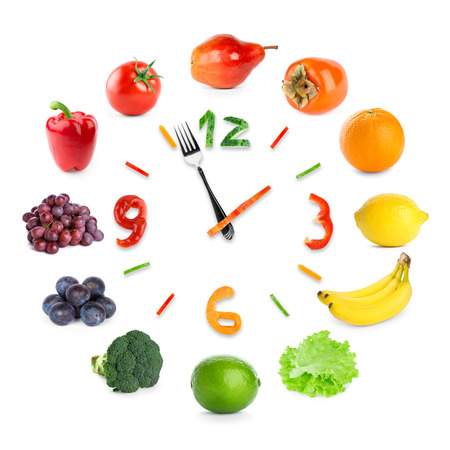 Food clock with fruits and vegetables on white background. Food conceptの写真素材