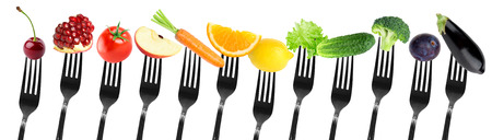 Color fruits and vegetables on fork on white background. Fresh foodの写真素材