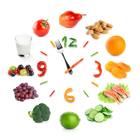 Food clock with healthy food on white background. Food conceptの写真素材