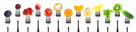 Fruits and vegetables on fork on white background. Fresh foodの写真素材