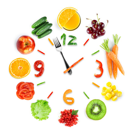 Food clock with fresh fruits and vegetables. Healthy foodの写真素材