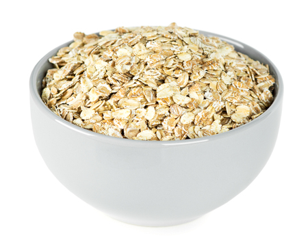 Oat flakes in bowl closeup on whiteの写真素材