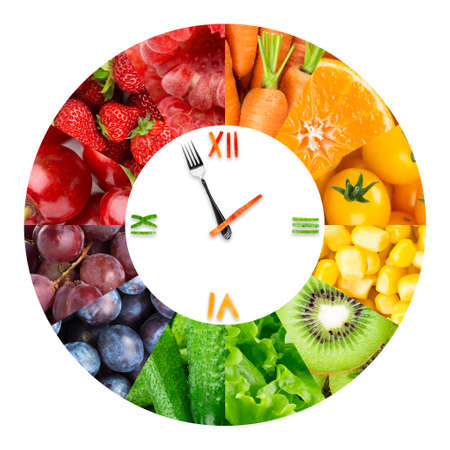 Food clock with fresh fruits and vegetables. Healthy foodの写真素材