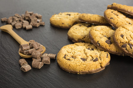 chocolate chip cookies with wooden spoon and chocolate chipsの写真素材