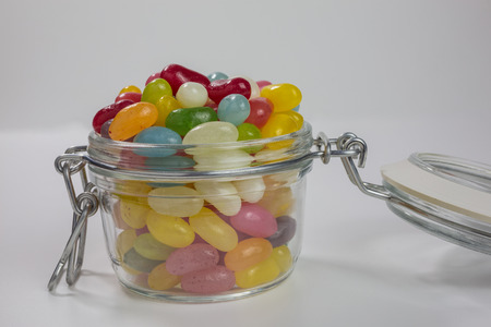 jelly beans of different colors and flavors in a glass jar