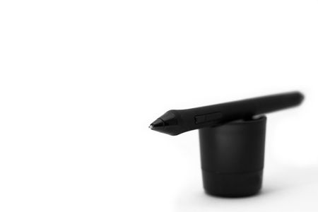 A graphic-tablet pen on a stand with only the tip in focus
