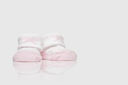 A pair of pink baby shoes on a clean background
