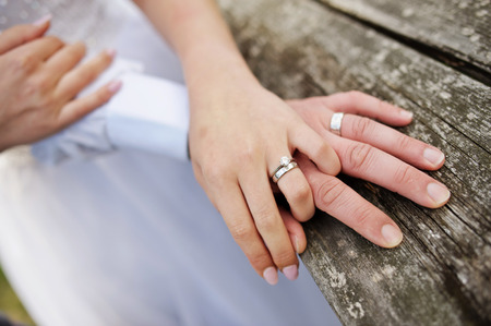Hands of spouses being in the amorous touch on the wooden railing of stairsの写真素材