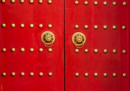 Red door with lion heads in asian style. Red wooden gates with golden details.の写真素材