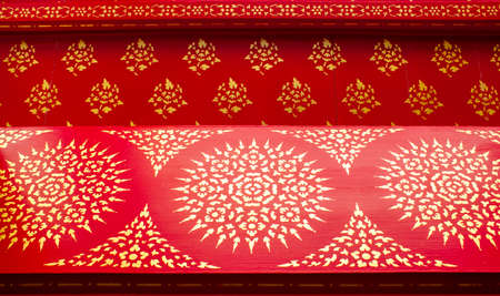 Asian golden pattern on red wooden background. Thai ornaments.の写真素材