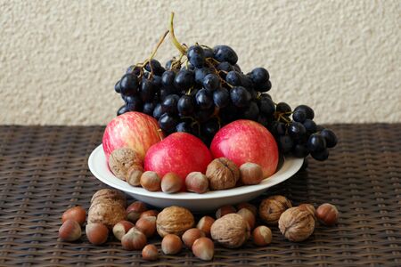 Still life: blue grapes, red apples, nuts.の写真素材
