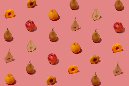 Creative pattern made with fresh pears and peaches on pastel pink background. Minimal summer fruit arrangement.の写真素材