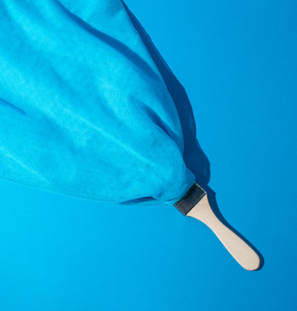 Vintage style concept with paint brush and blue mesh fabric. Monochromatic background. Retro fashion aesthetic.の写真素材