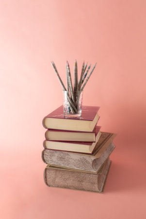 Ordered books and pencils on pastel pink background. Minimal education concept. flat lay.の写真素材