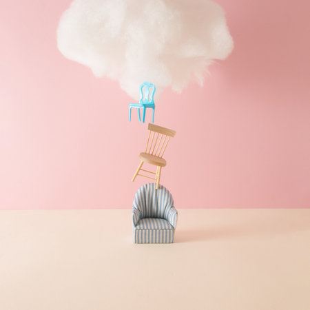 Stacked chairs with cloud against coral color background. Minimal success concept background.の写真素材