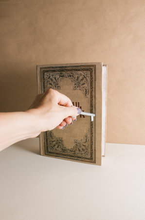 Hand with key opening a book. Minimalism. In front view.の写真素材