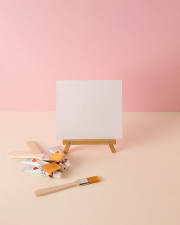 Paint brushes, paint tubes and canvas on pastel background. Minimal concept. Copy spaceの写真素材