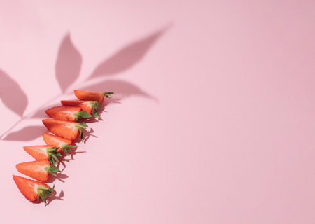 Creative summer background composition with strawberry pieces. Minimal top view fruit concept.の写真素材
