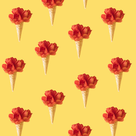 Ice cream cone with red tulip flowers pattern to yellow background. Minimal spring concept.の写真素材