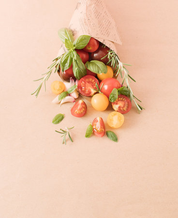 Cherry tomatoes and spices in a paper bag. Minimal food concept. Close up. Copy space.の写真素材