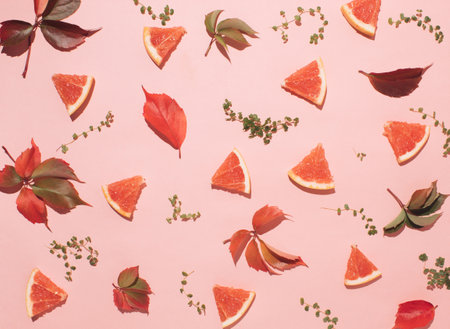 Autumn colorful pattern made of grapefruits and leaves. Flat lay