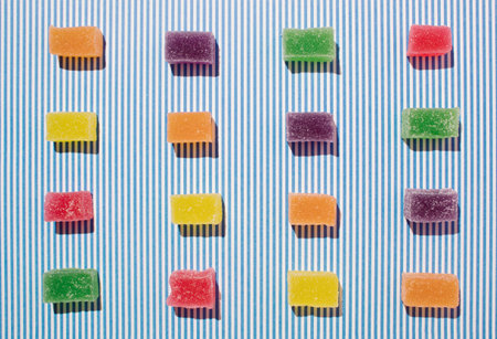 Creative colorful jelly candy pattern against blue white stripes background. Flat layの写真素材