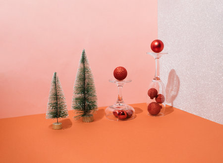 Christmas decoration red balls and mini Christmas trees in glasses with shiny background. New Year's minimal concept.の写真素材
