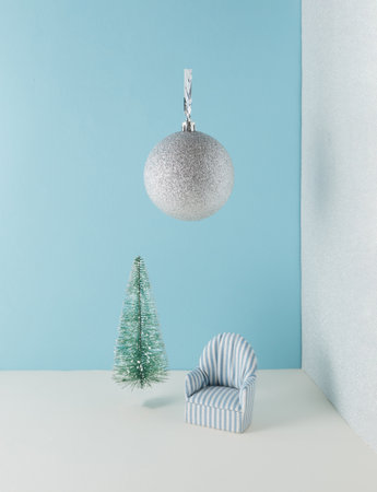 Creative hristmas composition. Armchair with Christmas bauble decoration on blue background. Happy holidays new year minimal concept.の写真素材