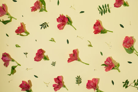 Creative pattern made of pink flowers and small leaves on pastel beige background. Minimal style....