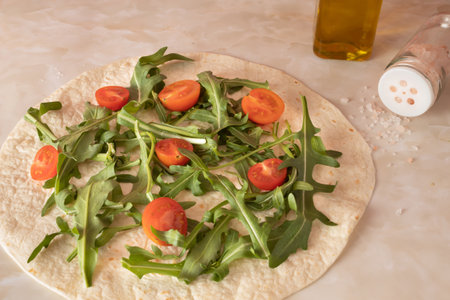 Angle view of fresh arugula and cherry tomato tortilla. Close-upの写真素材