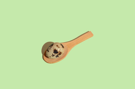 Wooden spoon with quail egg, mint background. Flat lay patternの写真素材