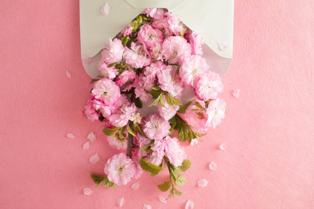 Mint envelope full of pink flowers. Flat lay. Love concept.