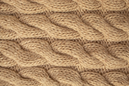 Winter wool hand-knit beige sweater. Clothes textile background