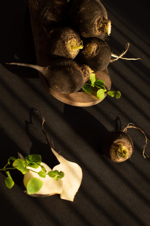 Black radishes on the table on black background. Still lifeの写真素材