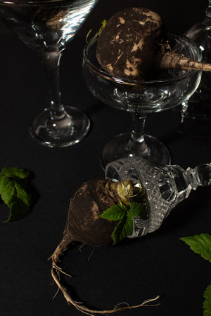 Black radishes in glasses on black background. Still lifeの写真素材