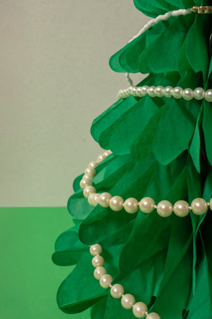 Necklace of white pearls on a green paper Christmas tree.の写真素材