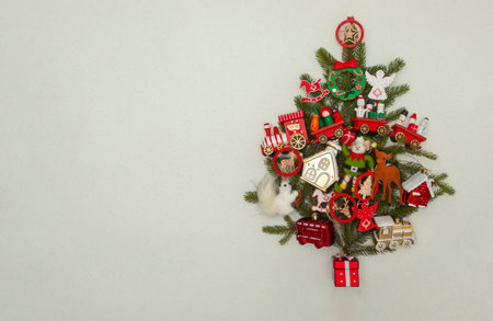 Christmas tree made of evergreen branches and colorful Christmas decoration on bright background with copy space. Invitation conceptの写真素材